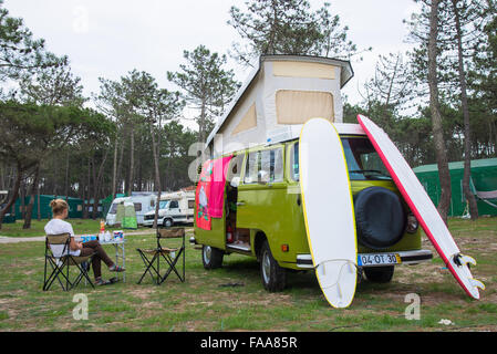 Mädchen sitzen beiseite Bulli mit Surfbrettern auf Campingplatz in portugal Stockfoto