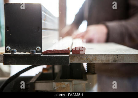 Tischler arbeiten mit Türstöcken elektrische Kreissäge Tabelle verwenden. Sägemehl-Partikel sind in der Luft sichtbar Stockfoto