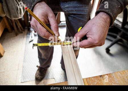 Tischler arbeiten mit Türstöcken. Er ist Holz messen und markieren mit Bleistift Stockfoto