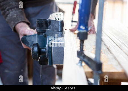 Tischler arbeiten mit Türpfosten mit elektrischen Hobel auf vertikale position Stockfoto