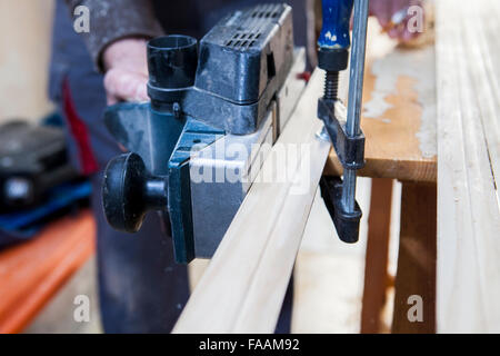 Tischler arbeiten mit Türpfosten mit elektrischen Hobel auf vertikale position Stockfoto