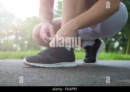 Mann, die Schnürsenkel zu binden, in den Park laufen Stockfoto