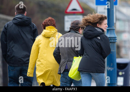 Aberystwyth Wales UK, Weihnachtstag, Leute Freitag, 25. Dezember 2015 auf der Promenade in Aberystwyth für ein Pre Weihnachten Mittagessen Spaziergang finden Sie Bedingungen luftig wie der Wind im Zuge der Sturm Eva wieder aufhebt.  Viele "Amber" Warnungen das Met Office sind für Nord-Wales und der North West Of England, ein weiterer Gürtel mit heftigem Regen zu rechnen ist Streikrecht von Nachmittag Photo Credit: Keith Morris / Alamy Live News Stockfoto