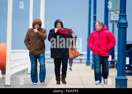 Aberystwyth Wales UK, Weihnachtstag, Leute Freitag, 25. Dezember 2015 auf der Promenade in Aberystwyth für ein Pre Weihnachten Mittagessen Spaziergang finden Sie Bedingungen luftig wie der Wind im Zuge der Sturm Eva wieder aufhebt.  Viele "Amber" Warnungen das Met Office sind für Nord-Wales und der North West Of England, ein weiterer Gürtel mit heftigem Regen zu rechnen ist Streikrecht von Nachmittag Photo Credit: Keith Morris / Alamy Live News Stockfoto