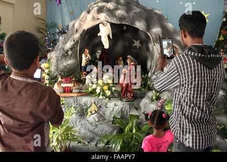 Medan, Indonesien. 25. Dezember 2015. Christen in Indonesien nehmen ein Hintergrundbild, der Geburtsort von Jesus Christus nach der Umsetzung der Weihnachtsfeier in der katholischen Kirche Graha Maria Annai Velangkanni, in Medan, Nord-Sumatra, Indonesien am 25. Dezember 2015 sein. Auf der ganzen Welt markieren Milliarden Christen Weihnachten, die traditionellen Geburtstag von Jesus Christus. Bildnachweis: Ivan Damanik/Alamy Live-Nachrichten Stockfoto