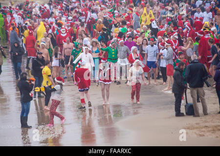 Bournemouth, Dorset, Großbritannien. Dezember 2015. Weihnachtliches Bad in Boscombe, Bournemouth, Dorset, Großbritannien am Weihnachtstag. Mutige Freiwillige stürzen sich trotz des feuchten nebeligen windigen Wetters ins kalte Meer, um zum 8. Jährlichen Wohltätigkeitsbad am Weihnachtsmorgen zu schwimmen, gekleidet in ausgefallene Kostüme und Geld für Macmillan Caring vor Ort in Christchurch zu sammeln, einer spezialisierten Palliative Care Unit für Patienten in der lokalen Gemeinde. Hunderte nahmen an der Veranstaltung Teil, die für viele vor ihrem Mittagessen eine beliebte Tradition geworden ist. Quelle: Carolyn Jenkins/Alamy Live News Stockfoto