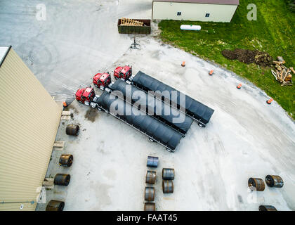 Luftaufnahme von Drohne Semi-Traktor-Anhänger mit planen und Frames geparkt auf Parkplatz mit Roll gebildet Stahl-coils Stockfoto