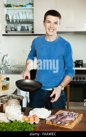 Mann Kochen Tintenfischringe im Teig Stockfoto