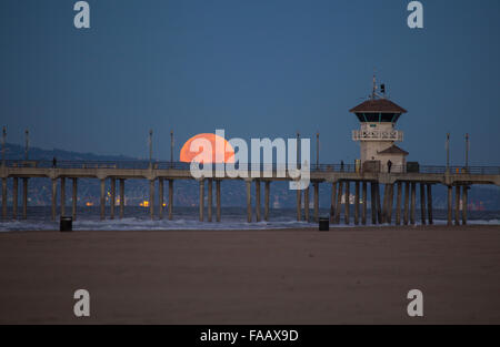 Der Vollmond am Weihnachtstag am Huntington Beach Pier Kalifornien USA 25. Dezember 2015 festlegen. Zum ersten Mal in 38 Jahren. Vollmond ist auch bekannt als ein voller Kalter Mond Stockfoto