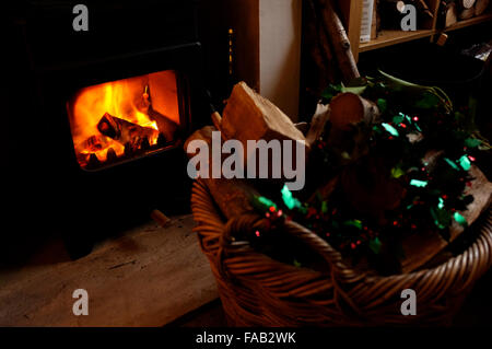 Melden Sie sich verbrennen, Herd und Feuer brennt mit Log Korb Beifahrerseite in Stadt von Canterbury nach Hause in East Kent uk Dezember 2015 Stockfoto