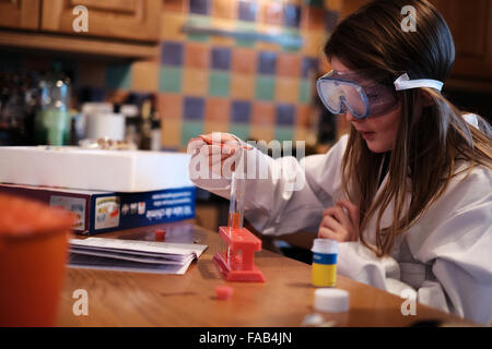 Junges Mädchen im weißen Kittel mit Wissenschaft Chemiebaukasten spielen Stockfoto