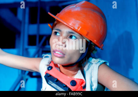 Junge attraktive Asiatin in Schutzhelm auf einer Baustelle Stockfoto
