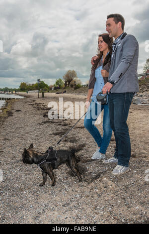 Paar, 25-30 Jahren, am Strand mit Hund Stockfoto