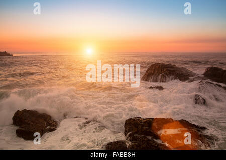 Meer Surfen während des atemberaubenden Sonnenuntergangs. Stockfoto