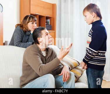 normale Eltern beschimpfen Teenager-Sohn im Wohnzimmer Stockfoto