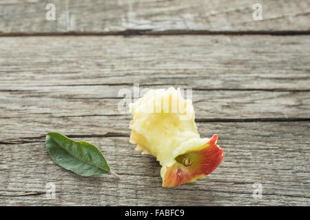 Braeburn Apfel-Kern, mit grünen Blättern auf rustikalem Holzbrett Stockfoto