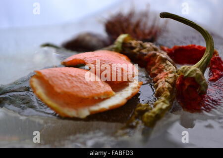 Orange Peel Paprika Kastanie in schmelzendem Eis gefroren Stockfoto