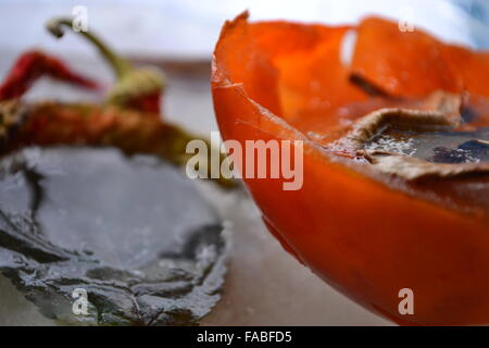 Gefrorene Paprika Persimone Blatt in schmelzendem Eis Stockfoto