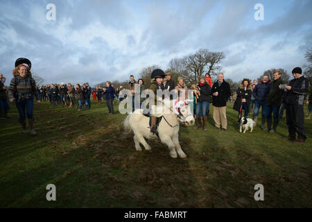 Ein junges Kind Ponyreiten folgt Mitglieder der Chiddingfold Leconfield und Cowdray Jagd, wie sie, die traditionelle Boxing Day Jagd in Petworth Park Petworth, West Sussex, England beginnen. Stockfoto