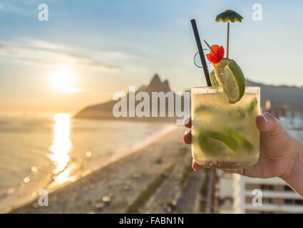 Eine köstliche Kiwi Caipirinha Drink mit Blick auf den berühmten Strand von Ipanema in Rio De Janeiro, Brasilien Stockfoto