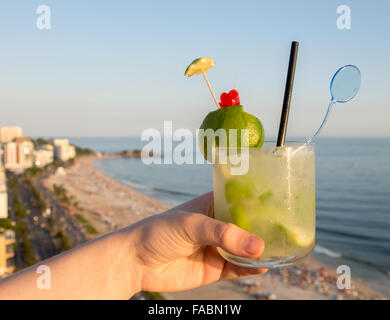 Eine köstliche Kiwi Caipirinha Drink mit Blick auf den berühmten Strand von Ipanema in Rio De Janeiro, Brasilien Stockfoto