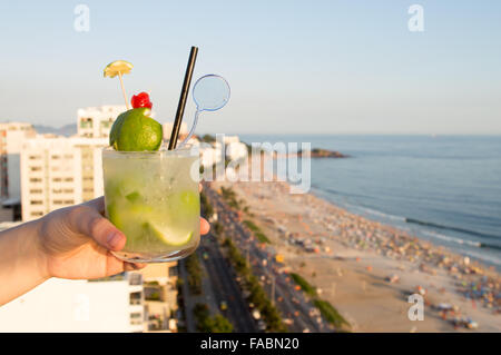 Eine köstliche Kiwi Caipirinha Drink mit Blick auf den berühmten Strand von Ipanema in Rio De Janeiro, Brasilien Stockfoto