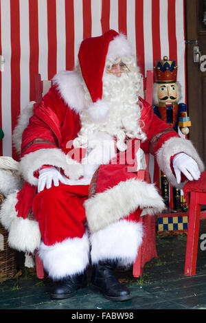 Weihnachtsmann, die Geschenke an Kinder in Santas Grotte Stockfoto