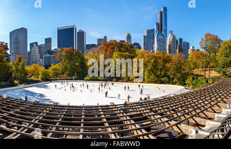 Wollman Eisbahn an einem sonnigen Morgen im Herbst, South Central Park und Midtown Manhattan Wolkenkratzer. New York City Stockfoto