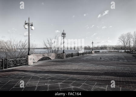 Gehweg entlang des Dnepr Flusses im Stadtteil Obolon Kiew, Ukraine. Weiche Sonne bei einem kalten Wintermorgen. Stockfoto