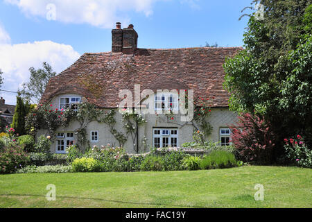 Malerischen traditionellen englischen Dorf Haus und Garten mit Kletterrosen an der Wand Stockfoto