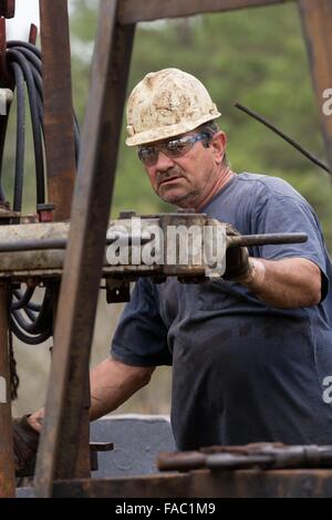 Ölarbeiter Waschbecken Rohre mit Hilfe einer Derrick für Rohöl in Evangeline, Louisiana zu bohren. Die Ölfelder wurden die ersten Brunnen in Louisiana. Stockfoto