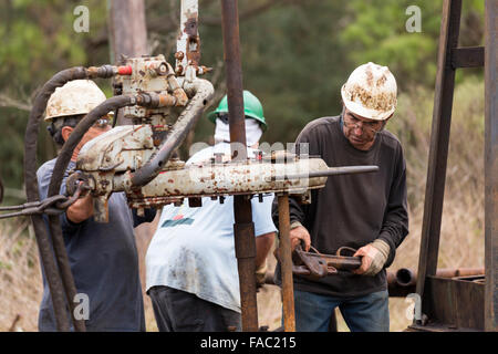 Ölarbeiter Waschbecken Rohre mit Hilfe einer Derrick für Rohöl in Evangeline, Louisiana zu bohren. Die Ölfelder wurden die ersten Brunnen in Louisiana. Stockfoto