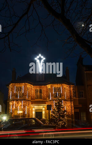 Ein Haus in Lichter zu Weihnachten mit einem Baum bedeckt und präsentiert Stockfoto