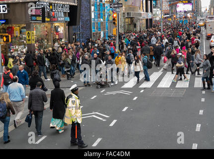 Times Square in New York voll von Menschen in den Weihnachtsferien (Boxing Day), einschließlich ein Verkehrspolizist regelt den Verkehr. Stockfoto