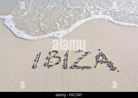 Ibiza, geschrieben im Sand am Strand mit Welle in Ibiza, Balearen, Spanien Stockfoto