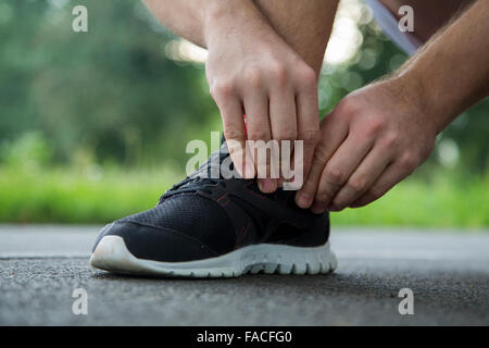 Mann, die Schnürsenkel zu binden, in den Park laufen Stockfoto