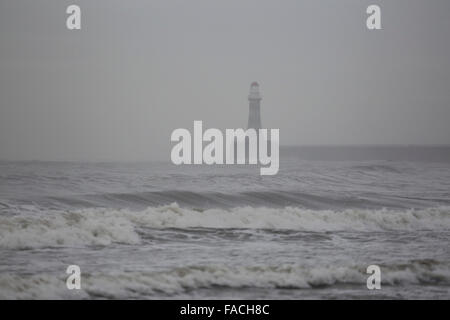 Strömendem Regen fällt in der Nordsee durch Roker Leuchtturm an einem grauen Wintertag in Sunderland, England. Die Mole und Leuchtturm e Stockfoto