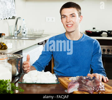 Gewöhnlicher Mensch Kochen rohen Tintenfisch in Küche Stockfoto