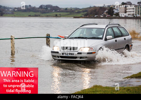 Eine Autofahrer fährt durch Hochwasser auf der Straße bei Storth an der Mündung der Kent in Cumbria, UK, während des Sturms Januar 2014 Stockfoto