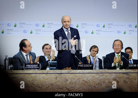 Der französische Außenminister Laurent Fabius erkennt Applaus nach erfolgreich Lenkung ein globales Abkommen auf Treibhausgasemissionen auf die COP21, United Nations Climate Change Conference 12. Dezember 2015 in Le Bourget, Frankreich. UN Secretary General Ban Ki-Moon und der französische Präsident Francois Hollande begrüßen. Stockfoto