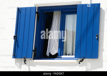 Öffnen Sie Fenster mit blauen Fensterläden in Griechenland Stockfoto