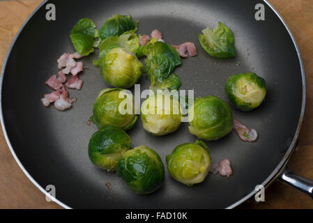 Rosenkohl und Speck in einer Pfanne erhitzen Stockfoto