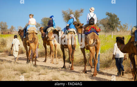 Kamel-Karawane-Safari-Tour mit Touristen in Thar-Wüste in der Nähe von Jaisalmer, Indien Stockfoto