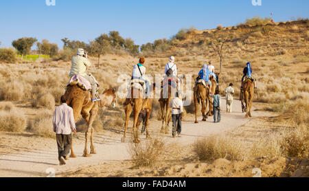Kamel-Karawane-Safari-Tour mit Touristen in Thar-Wüste in der Nähe von Jaisalmer, Indien Stockfoto