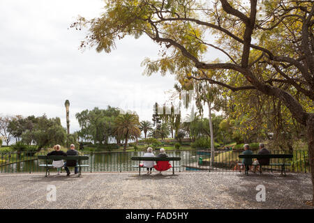 Drei Paare sitzen auf den Bänken im Park Santa Catarina. Funchal, Madeira Stockfoto