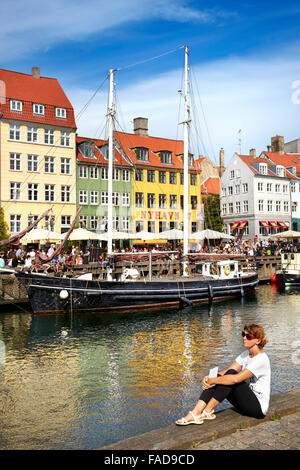 Turist entspannend am Nyhavn Kanal, Kopenhagen, Dänemark Stockfoto