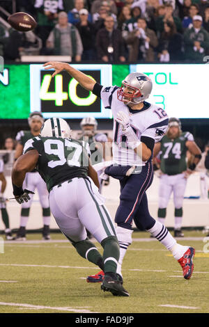 East Rutherford, New Jersey, USA. 27. Dezember 2015. New England Patriots Quarterback Tom Brady (12) wirft den Ball mit New York Jets außerhalb Linebacker Calvin Pace (97) kommen bei ihm während der NFL-Spiel zwischen den New England Patriots und die New York Jets MetLife Stadium in East Rutherford, New Jersey. Die New York Jets gewann 26-20. Christopher Szagola/CSM/Alamy Live-Nachrichten Stockfoto