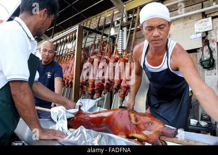 Arbeiter der Laloma in Quezon City (die Lechon Hauptstadt der Philippinen) bereitet die Lechon Baboy (gebratenes Schweinefleisch), die für die kommende Feier der Noche Buena oder Silvester Feier zur Abholung bereitstehen, nach der Lechonero (gebratenes Schweinefleisch kochen) kochen sie gebratene Schweinefleisch von 2 bis 3 Stunden, es hängt immer noch über die Größen und sie kochen es in traditionelle Weise oder manuelle Drehung des Schweinefleisches. Die Preise der Lechon Baboy (gebratenes Schweinefleisch) beginnen bei 4,00 Pesos bis zu 15.000 pro. (Foto von Gregorio B. Dantes Jr. / Pacific Press) Stockfoto