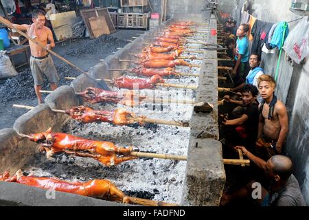 Arbeiter der Laloma in Quezon City (die Lechon Hauptstadt der Philippinen) bereitet die Lechon Baboy (gebratenes Schweinefleisch), die für die kommende Feier der Noche Buena oder Silvester Feier zur Abholung bereitstehen, nach der Lechonero (gebratenes Schweinefleisch kochen) kochen sie gebratene Schweinefleisch von 2 bis 3 Stunden, es hängt immer noch über die Größen und sie kochen es in traditionelle Weise oder manuelle Drehung des Schweinefleisches. Die Preise der Lechon Baboy (gebratenes Schweinefleisch) beginnen bei 4,00 Pesos bis zu 15.000 pro. (Foto von Gregorio B. Dantes Jr. / Pacific Press) Stockfoto