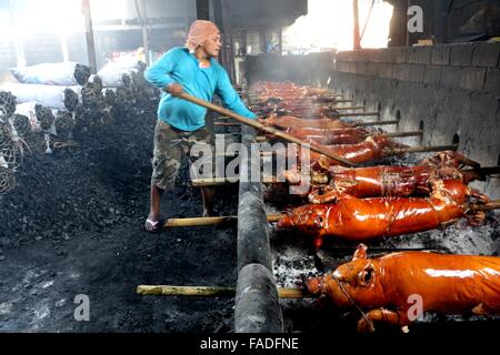 Arbeiter der Laloma in Quezon City (die Lechon Hauptstadt der Philippinen) bereitet die Lechon Baboy (gebratenes Schweinefleisch), die für die kommende Feier der Noche Buena oder Silvester Feier zur Abholung bereitstehen, nach der Lechonero (gebratenes Schweinefleisch kochen) kochen sie gebratene Schweinefleisch von 2 bis 3 Stunden, es hängt immer noch über die Größen und sie kochen es in traditionelle Weise oder manuelle Drehung des Schweinefleisches. Die Preise der Lechon Baboy (gebratenes Schweinefleisch) beginnen bei 4,00 Pesos bis zu 15.000 pro. (Foto von Gregorio B. Dantes Jr. / Pacific Press) Stockfoto